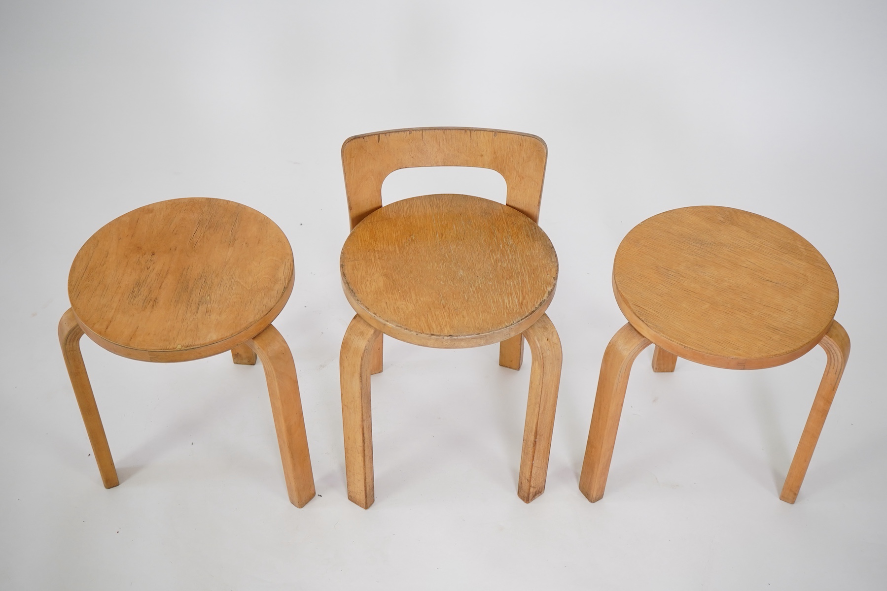 Alvar Aalto (Finnish 1898-1976) for Artek, distributed by Finmar: A pair of 'Model 60' stools and a similar 'K65' stool